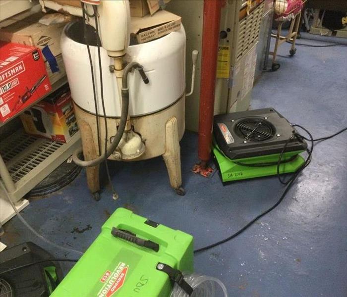 SERVPRO drying equipment in utility room with mechanicals and shelves