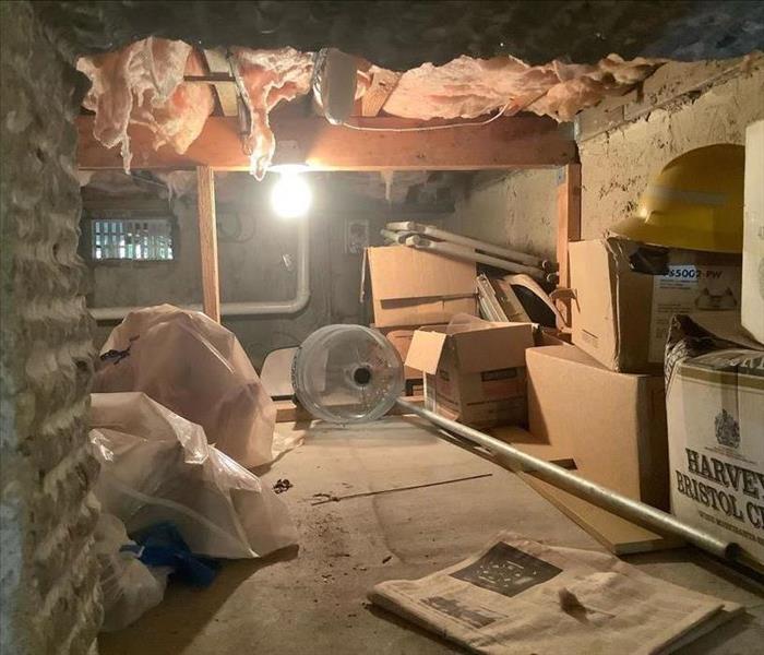 Crawlspace with hanging insulation and boxes