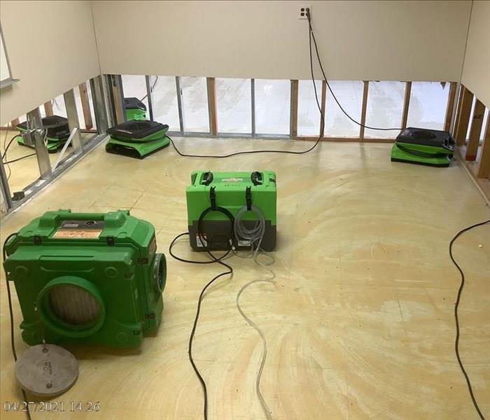 Office with SERVPRO drying equipment on slab floor with cut walls
