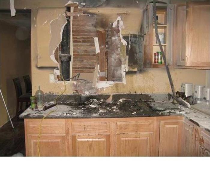 the burned back wall, fire debris-filled countertop, and plaster from the wall