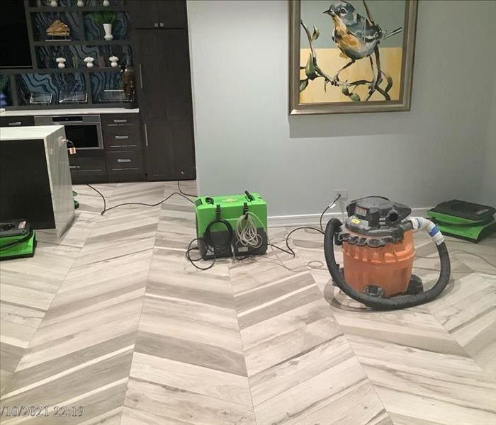 Room with hardwood floors and artwork on the wall by SERVPRO water damage equipment