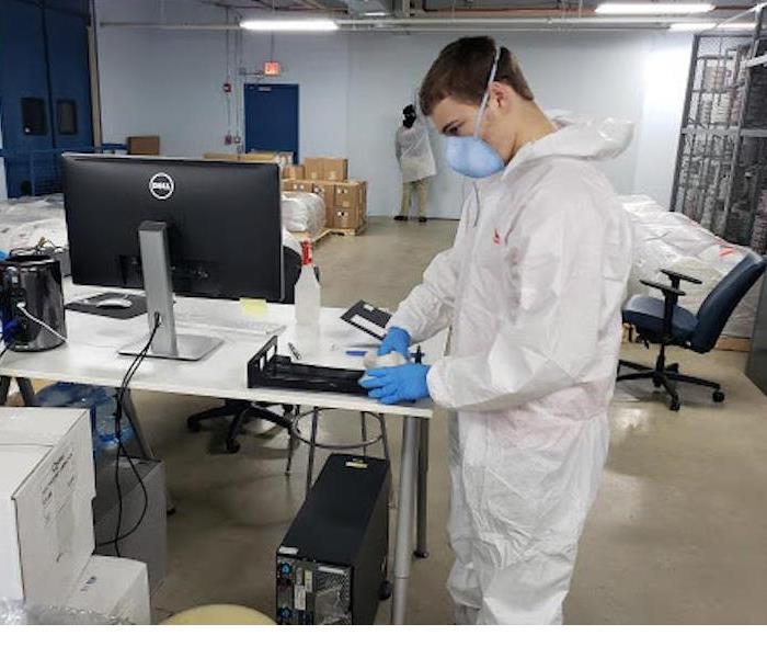 A SERVPRO employee with a white hazmat suit on. 