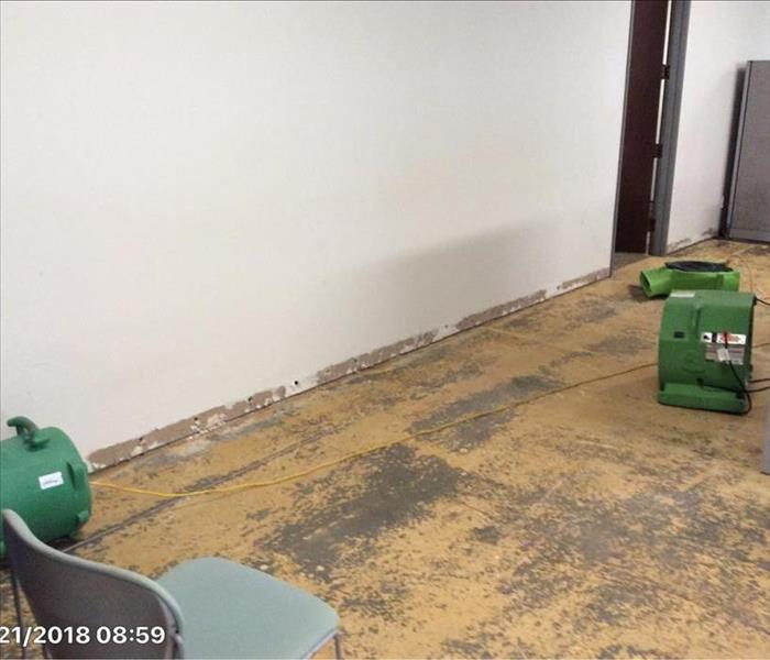 machines drying office with no carpet or baseboards, weep holes showing