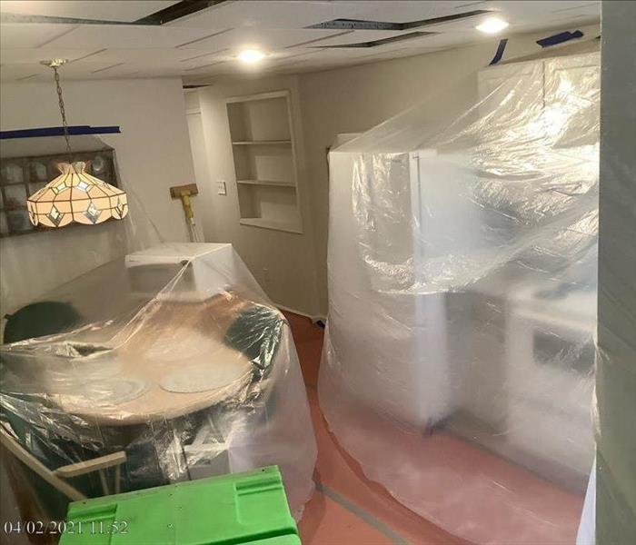 Kitchen with plastic-covered table, chairs and countertops