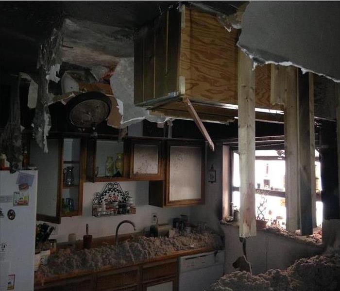 Kitchen with fire damage and debris 