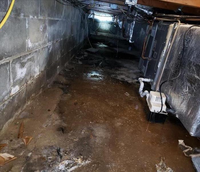 Crawlspace with water debris and ductwork 